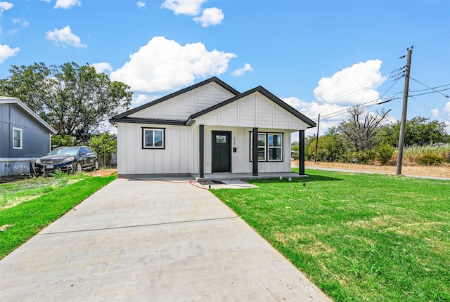 modern farmhouse featuring a porch and a front lawn