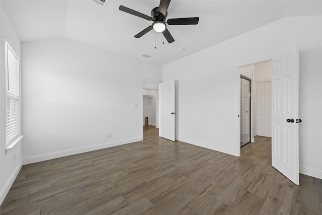 unfurnished bedroom featuring ceiling fan, dark hardwood / wood-style floors, vaulted ceiling, and multiple windows