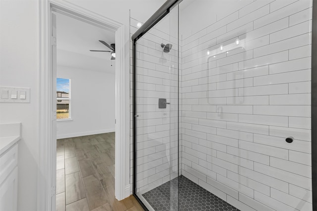 bathroom featuring a shower with shower door, ceiling fan, and hardwood / wood-style floors