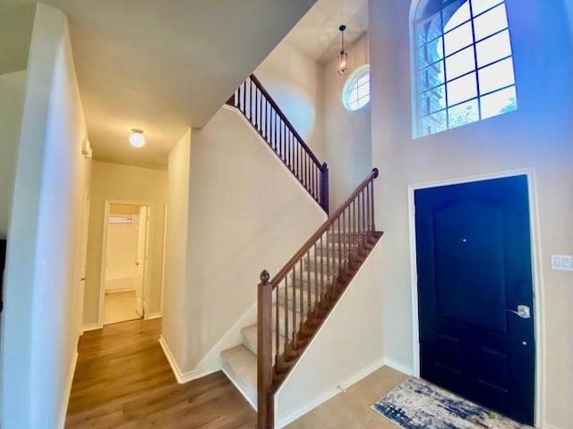 entrance foyer with wood-type flooring and a high ceiling