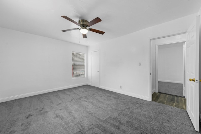 unfurnished room with ceiling fan and dark colored carpet