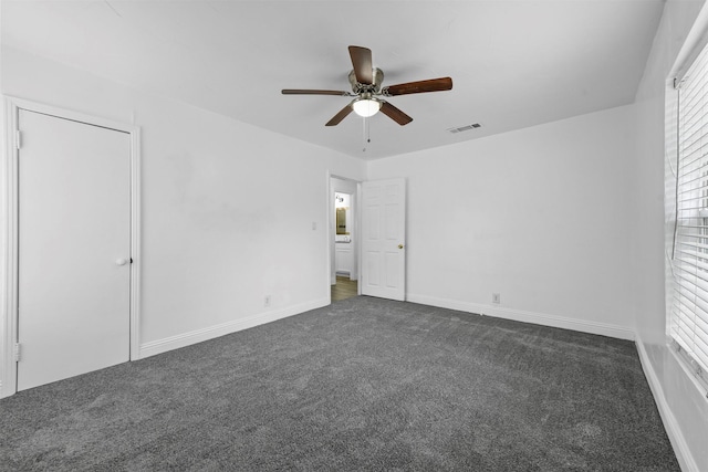 unfurnished bedroom with dark colored carpet and ceiling fan