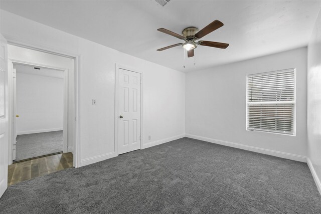 unfurnished bedroom featuring dark carpet and ceiling fan