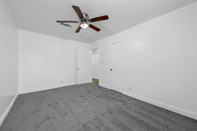 spare room with ceiling fan and dark carpet