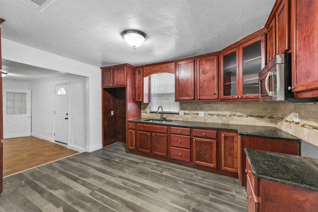 kitchen featuring tasteful backsplash, sink, dark hardwood / wood-style floors, and dark stone countertops