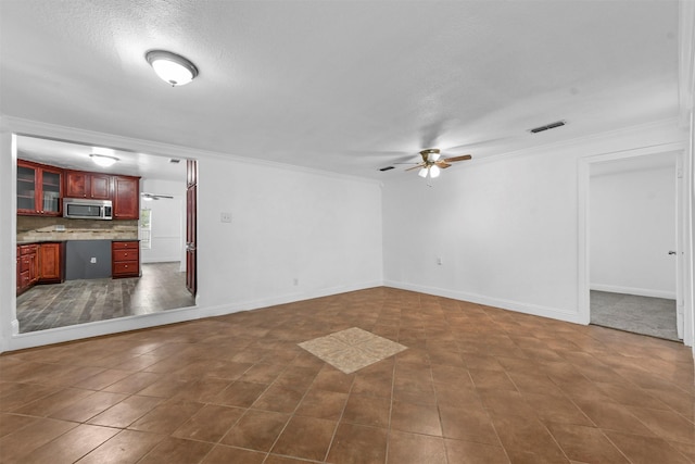 unfurnished living room featuring ornamental molding, a textured ceiling, and ceiling fan