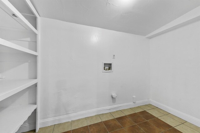 washroom featuring washer hookup and dark tile patterned flooring