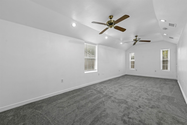 unfurnished room with dark carpet and vaulted ceiling