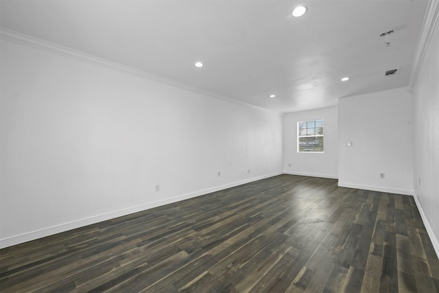 spare room with crown molding and dark wood-type flooring