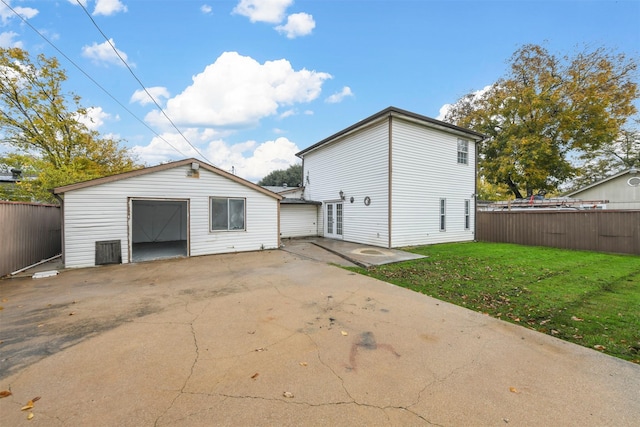 back of property with a lawn, an outdoor structure, and a patio