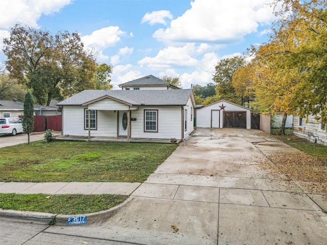 bungalow-style house with a garage, a porch, an outbuilding, and a front lawn