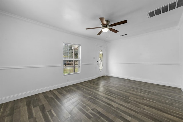 empty room featuring ornamental molding, dark wood-type flooring, and ceiling fan