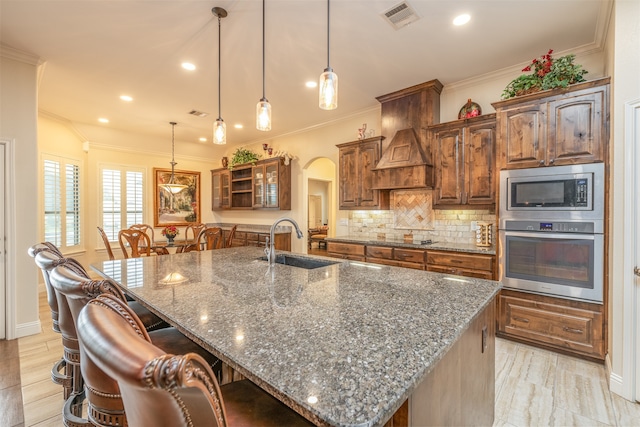 kitchen with pendant lighting, a large island, stainless steel appliances, and dark stone counters