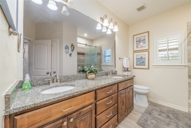 bathroom featuring vanity, toilet, hardwood / wood-style flooring, and a shower with door