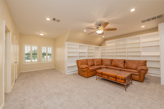 carpeted living room with ceiling fan and vaulted ceiling