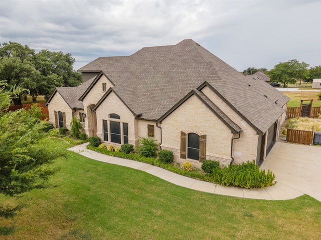 french country home featuring a front lawn