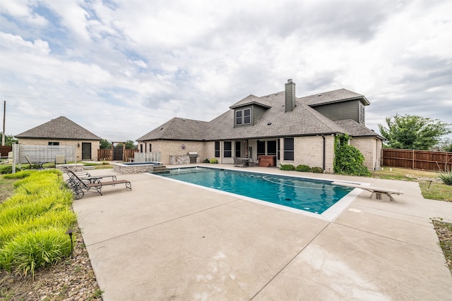 view of swimming pool featuring a patio area and a diving board