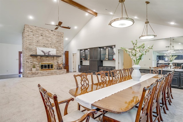 dining area featuring a fireplace, light carpet, ceiling fan, high vaulted ceiling, and beam ceiling