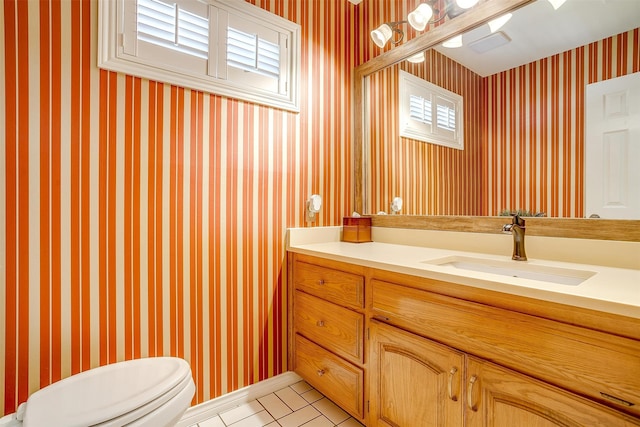 bathroom featuring a wealth of natural light, vanity, toilet, and tile patterned floors