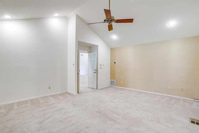 spare room with light colored carpet, ceiling fan, and high vaulted ceiling