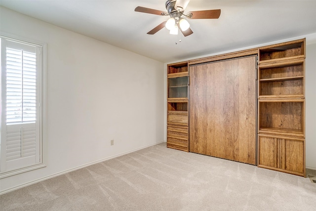 unfurnished bedroom featuring ceiling fan and light carpet