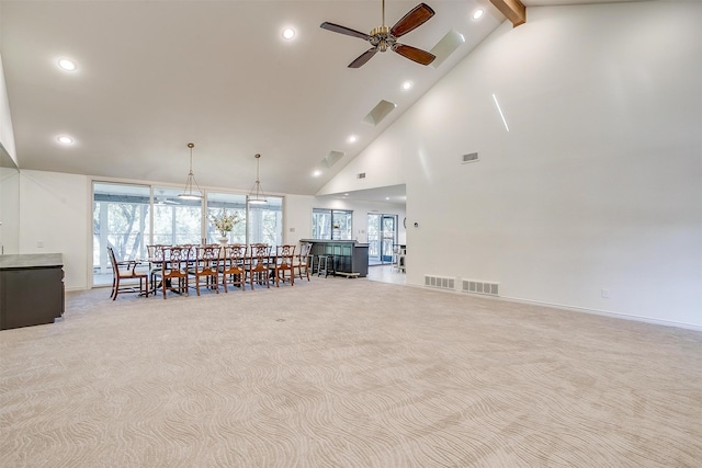 interior space featuring ceiling fan, light carpet, and high vaulted ceiling