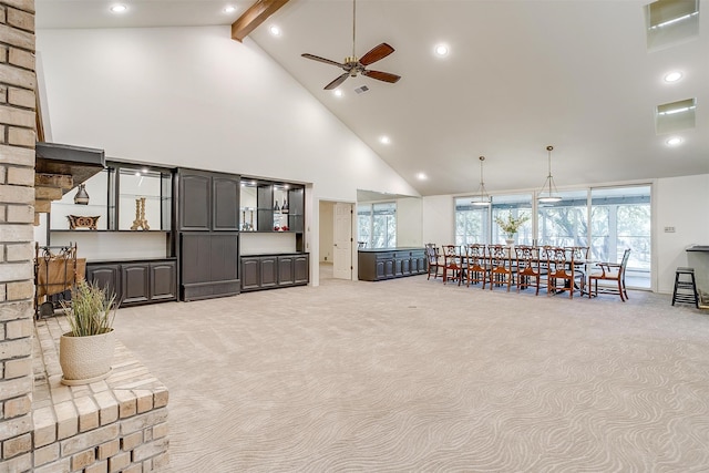 living room with high vaulted ceiling, ceiling fan, light colored carpet, and beam ceiling