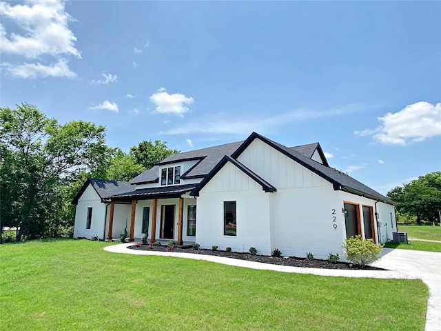 modern farmhouse with a porch, central air condition unit, and a front lawn