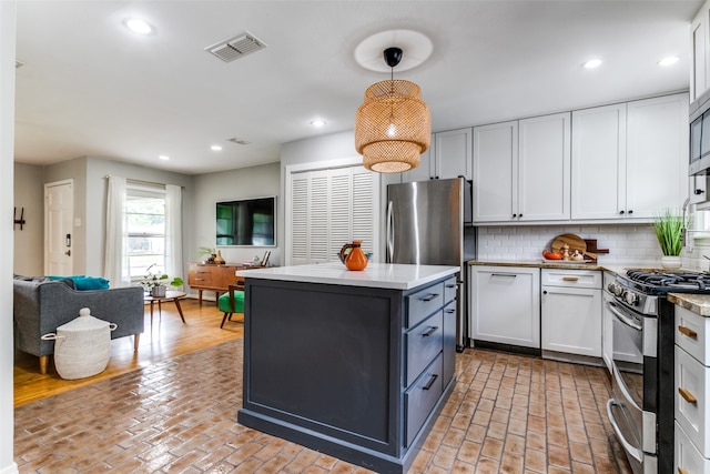 kitchen with stainless steel appliances, backsplash, white cabinetry, and hanging light fixtures