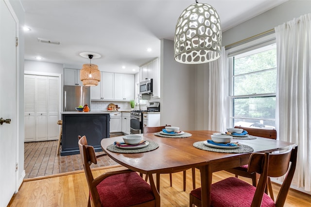 dining space with light hardwood / wood-style floors and a wealth of natural light