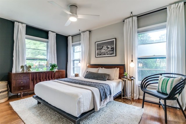 bedroom featuring multiple windows, ceiling fan, and wood-type flooring