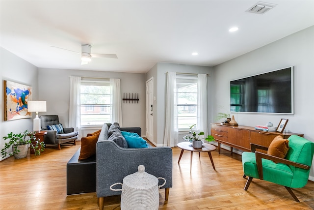 living room featuring a wealth of natural light, ceiling fan, and light wood-type flooring