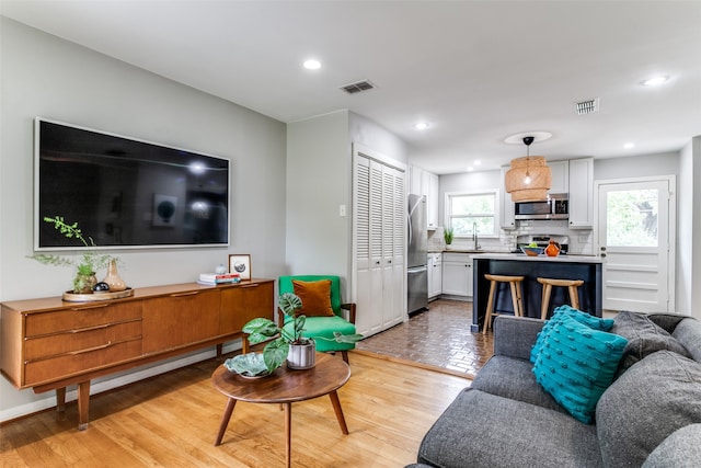 living room with light wood-type flooring and sink