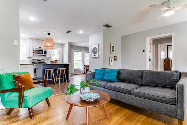 living room featuring ceiling fan and light hardwood / wood-style flooring