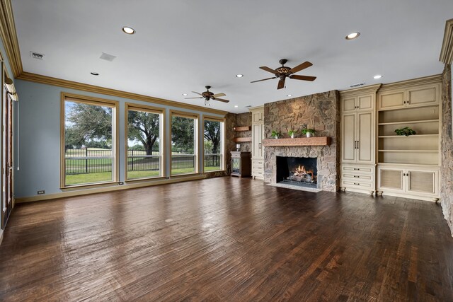 unfurnished living room featuring dark wood-type flooring, ceiling fan, ornamental molding, and a fireplace