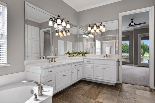 bathroom with ceiling fan with notable chandelier, vanity, crown molding, and a bathing tub