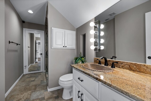 bathroom with lofted ceiling, vanity, and toilet