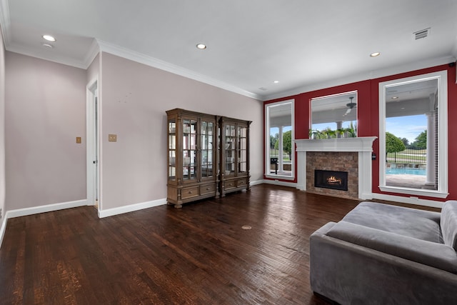 living room with dark wood-type flooring, plenty of natural light, a fireplace, and ornamental molding