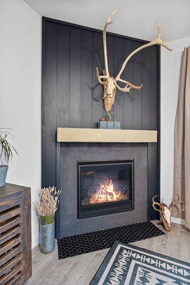 room details with hardwood / wood-style flooring, a fireplace, and a textured ceiling