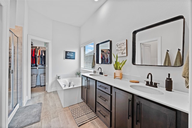 bathroom with independent shower and bath, wood-type flooring, and vanity