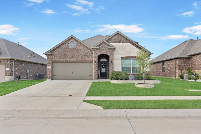 french country style house with brick siding, concrete driveway, an attached garage, a front yard, and central AC