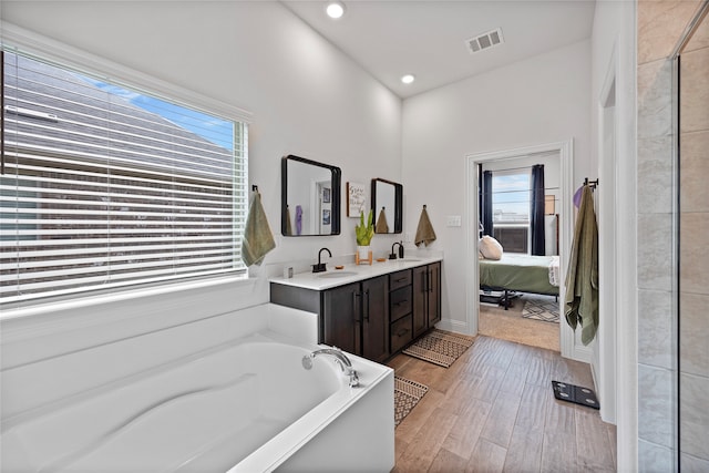 bathroom featuring a tub, hardwood / wood-style floors, and vanity