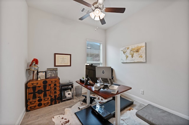 home office with light hardwood / wood-style flooring and ceiling fan