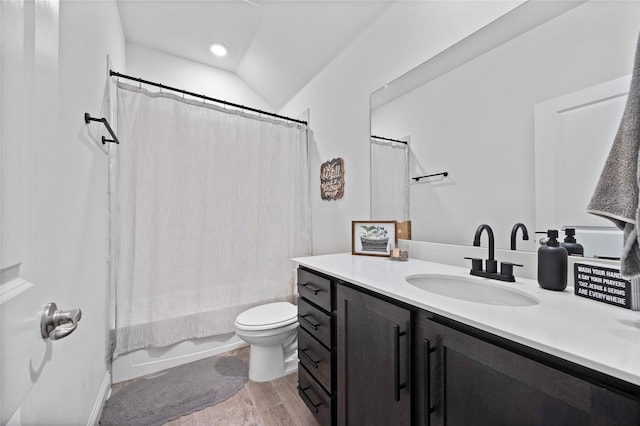 full bathroom featuring vanity, vaulted ceiling, hardwood / wood-style floors, toilet, and shower / bath combo