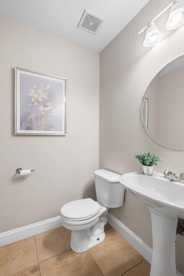 bathroom featuring toilet and tile patterned flooring