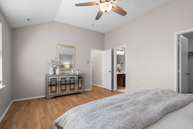 bedroom featuring light wood-type flooring, ceiling fan, lofted ceiling, a walk in closet, and ensuite bathroom