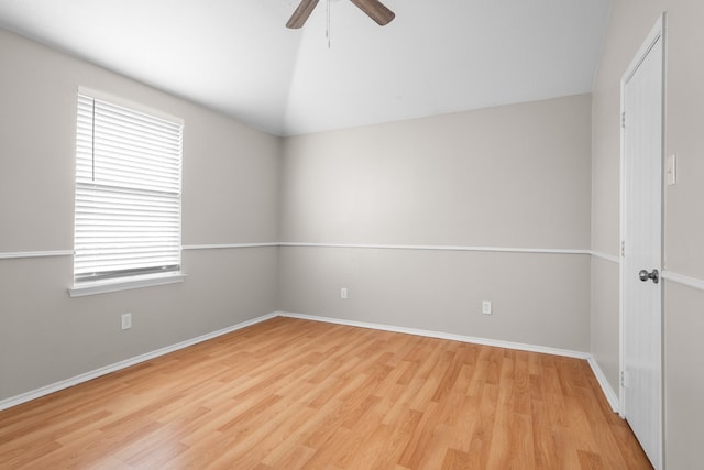 spare room with ceiling fan, plenty of natural light, wood-type flooring, and vaulted ceiling