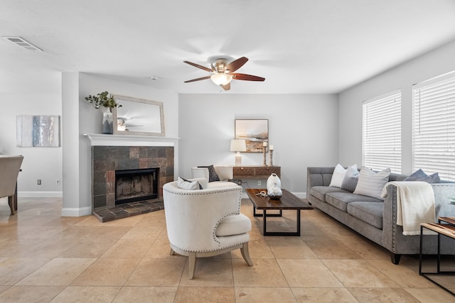 living room featuring light tile patterned floors, ceiling fan, and a tile fireplace