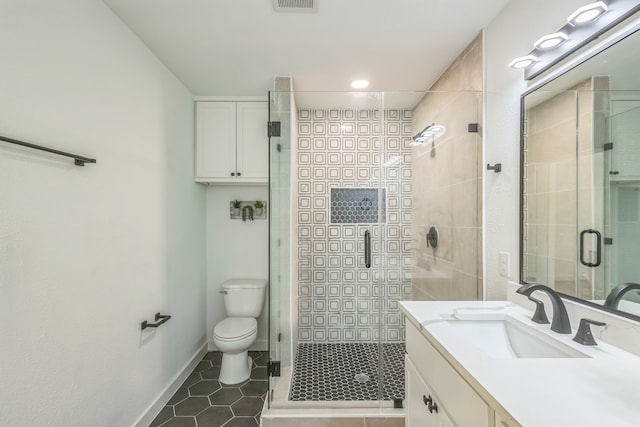 bathroom with tile patterned floors, toilet, a shower with door, and vanity