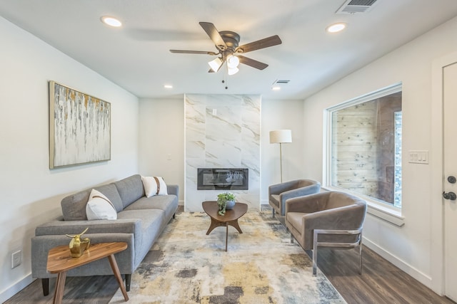 living room featuring ceiling fan, hardwood / wood-style flooring, and a fireplace